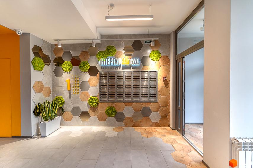 Сучасний дизайн вхідної групи ЖК Сирецькі сади з гексагональною плиткою та елементами декору. Опис новобудови з акцентом на інтер'єр лобі.