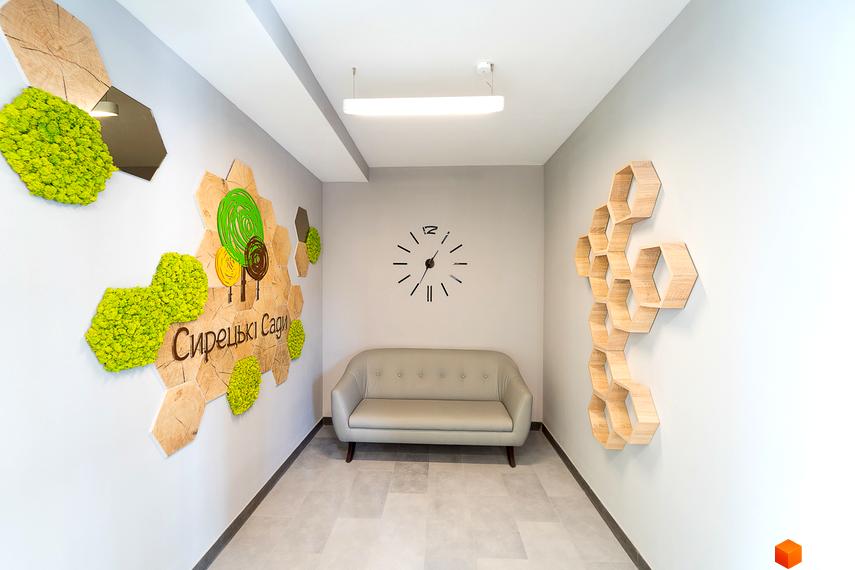 Новобудова ЖК Сирецькі сади: затишна зона відпочинку з диваном та декоративним оформленням стін.