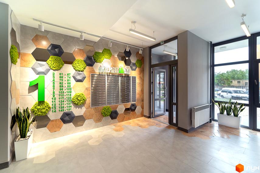 Лобі житлового комплексу Сирецькі сади з оригінальним дизайном стін та підлогою. Вхідна група з дверима та вікнами, що виходять на вулицю.