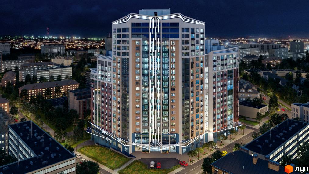 Висотна будівля ЖК Лук'янівський каскад у вечірню пору. Фасад будинку з великою кількістю вікон, підсвічування. На прибудинковій території є зелені насадження та парковка.