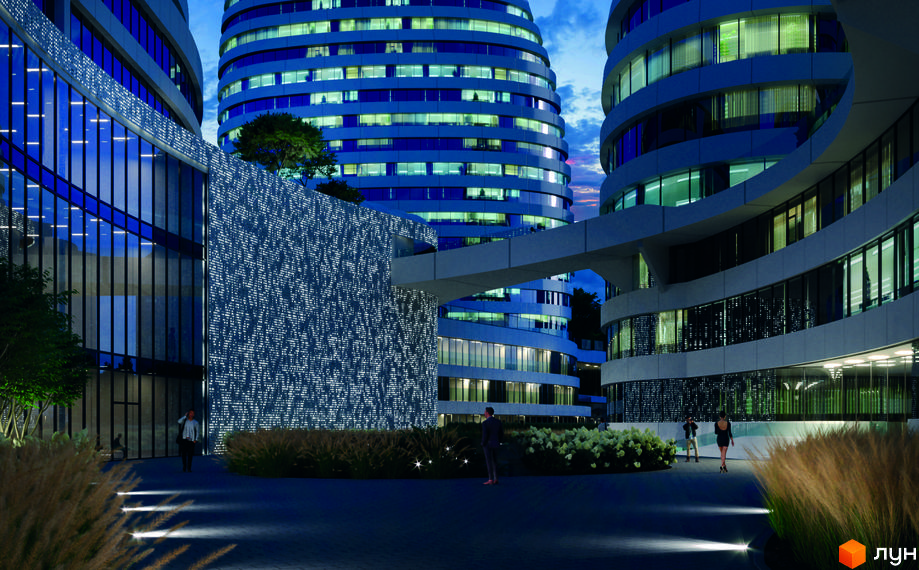 БФК INTERGAL CITY: Вечірній вигляд будівель з вигнутими фасадами, освітленими вікнами та декоративною підсвіткою на стінах. Прибудинкова територія з доріжками та зеленню.