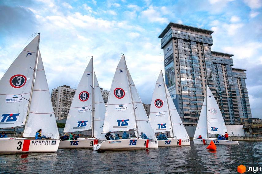 Житловий комплекс RiverStone на фоні регати. На передньому плані вітрильники, на задньому – сучасна архітектура будинку.