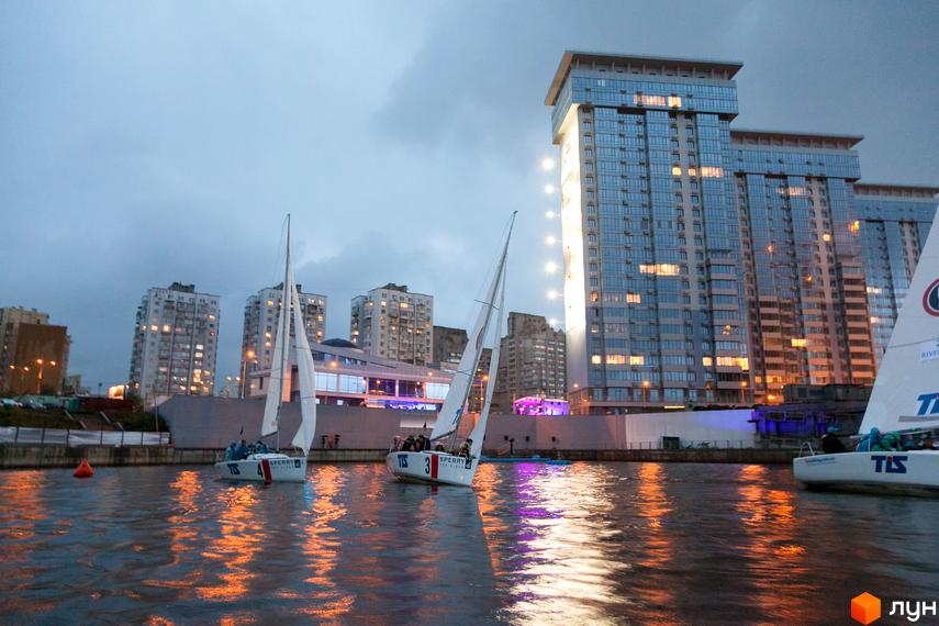 Житловий комплекс RiverStone з сучасними фасадами та прибудинковою територією біля води, яхти на фоні.