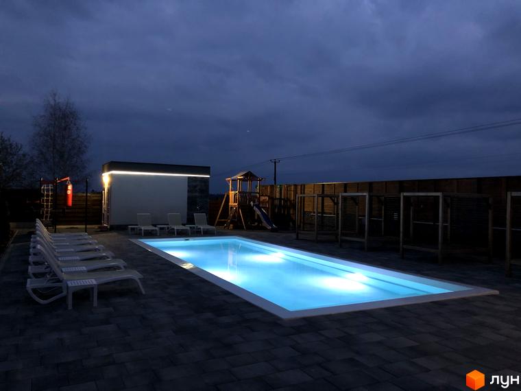 Басейн у дворі Котеджного містечка Crystal Forest. На території розташовані шезлонги та дитячий майданчик.