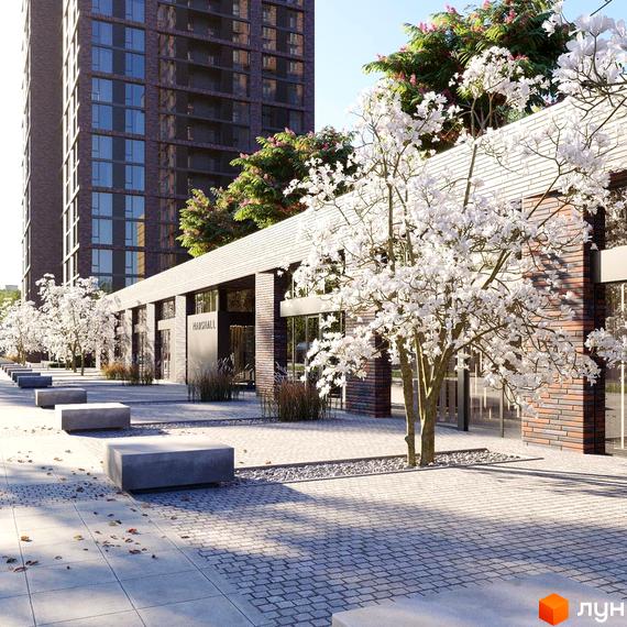 Житловий комплекс MARSHALL з цегляним фасадом та білими квітучими деревами на прибудинковій території. Проєкт новобудови з лаконічними лавками та бруківкою.