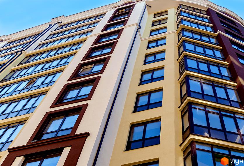 Зображення фасаду Житлового комплексу Лісова казка з великими вікнами. Багатоповерховий будинок з оздобленням у світлих тонах.