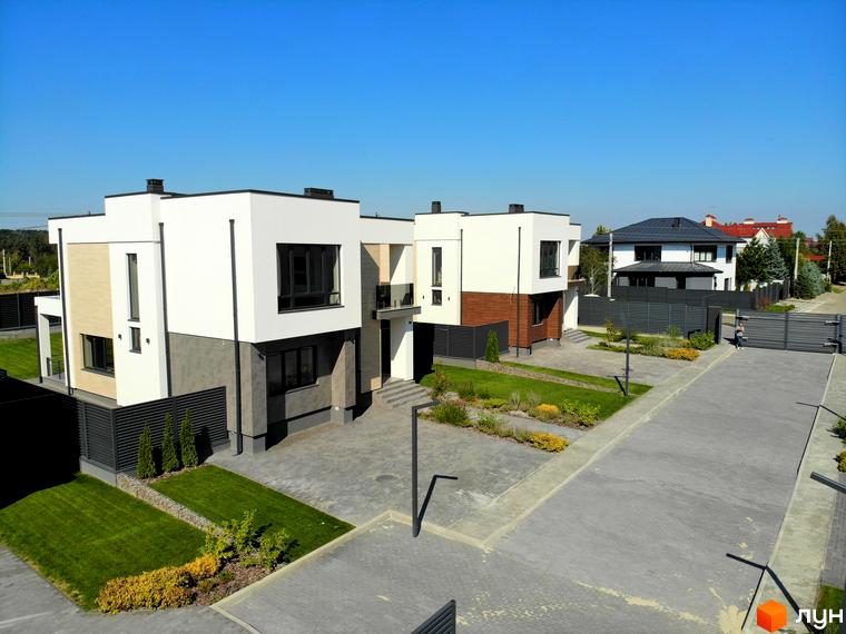 Вигляд Котеджного містечка Full House з двоповерховими будинками та озелененою територією. На передньому плані брукована дорога.