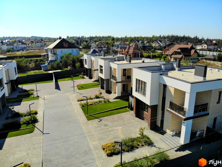 Зображення Котеджного містечка Full House з виглядом на фасади будинків та прибудинкову територію з газонами.