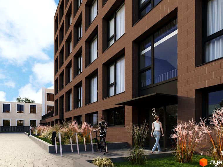 Зовнішній вигляд новобудови ЖК AMSTERDAM з коричневої цегли та прибудинкова територія з рослинністю та велосипедами. Сучасний житловий комплекс для комфортного життя.