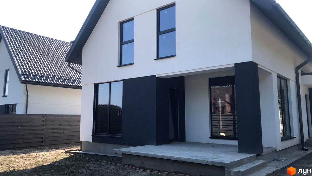 Фасад будинку Житловий комплекс по вул. Садова з великими вікнами та темними акцентами. На передньому плані бетонний майданчик та газон.