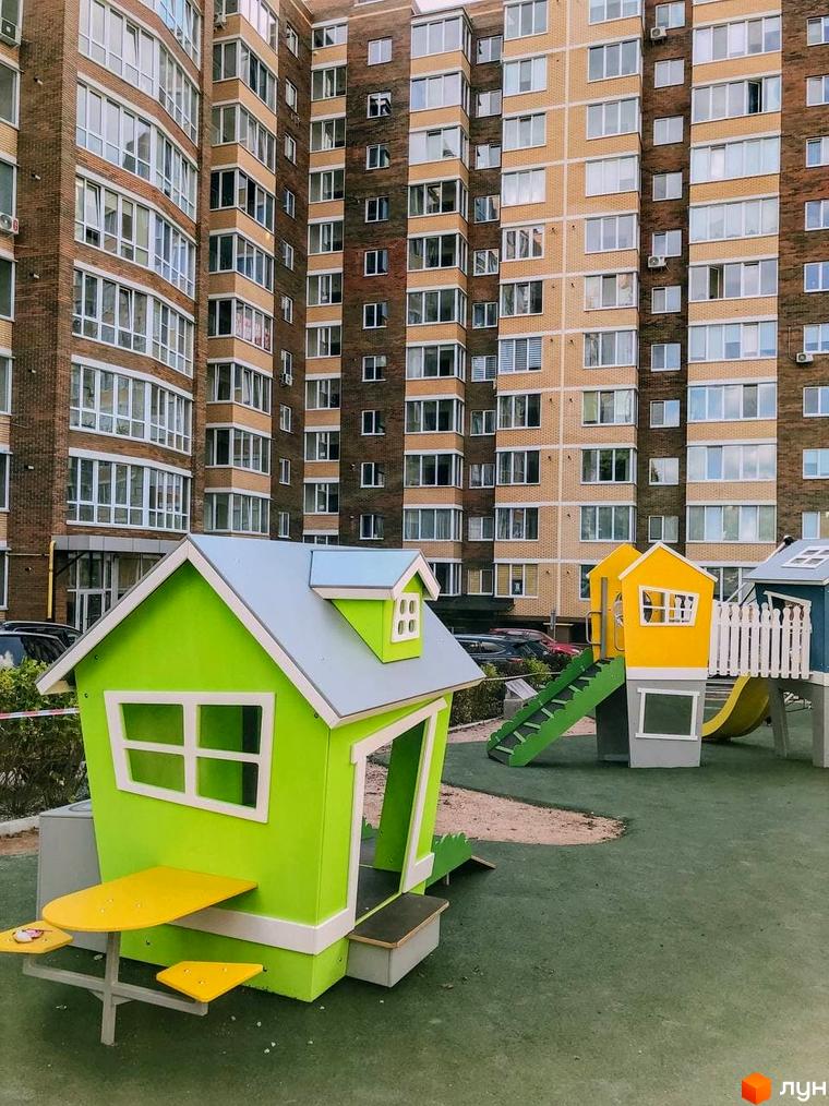 Житловий комплекс Преміум Парк. Зовнішній вигляд будівель та дитячий майданчик з гірками та будиночками.