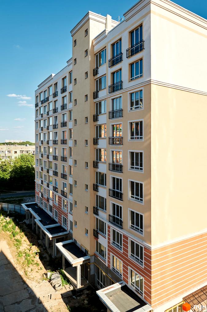 Зображення фасаду багатоповерхового будинку в Житловому комплексі Нові Теремки. Вигляд новобудови з великою кількістю вікон та балконів.