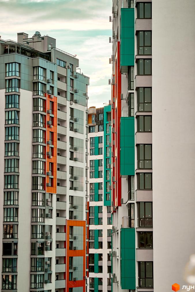 Висотна будівля ЖК Crystal Avenue з панорамними вікнами та кольоровими фасадами. Архітектура житлового комплексу поєднує в собі сучасні рішення та зручність.
