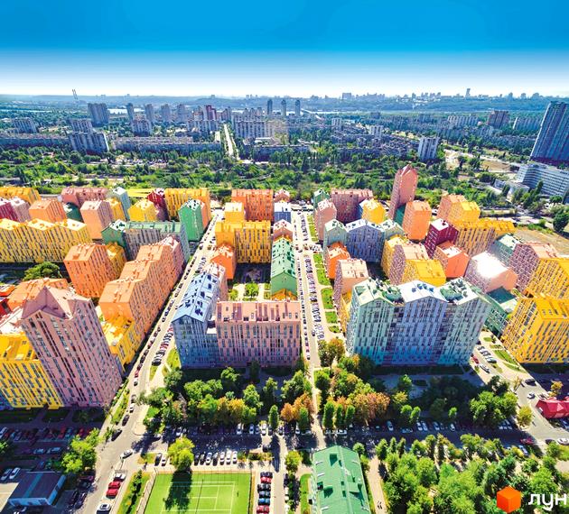 Житловий комплекс Комфорт Таун з кольоровими будинками та прибудинковою територією з зеленими насадженнями.