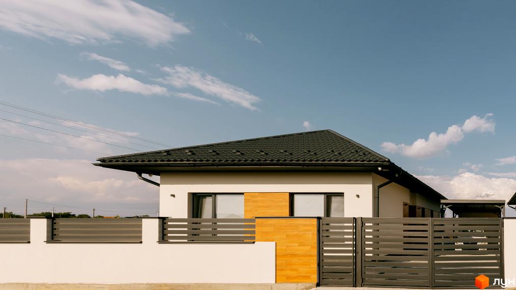 Білий будинок з темним дахом та парканом. КМ HAPPY HOUSING - ідеальне місце для життя з комфортом та затишком.