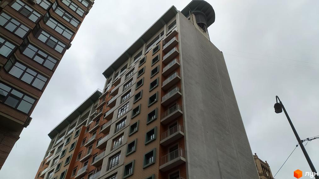 Зовнішній вигляд житлового комплексу Капітолій з цегляним фасадом та балконами. Фото новобудови з різних ракурсів.