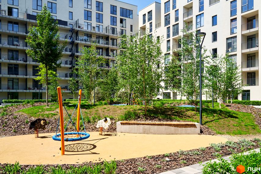 Житловий район Rybalsky: сучасний житловий комплекс з дитячим майданчиком та зоною відпочинку. Фасади будівель виконані в світлих тонах, з великою кількістю скління.