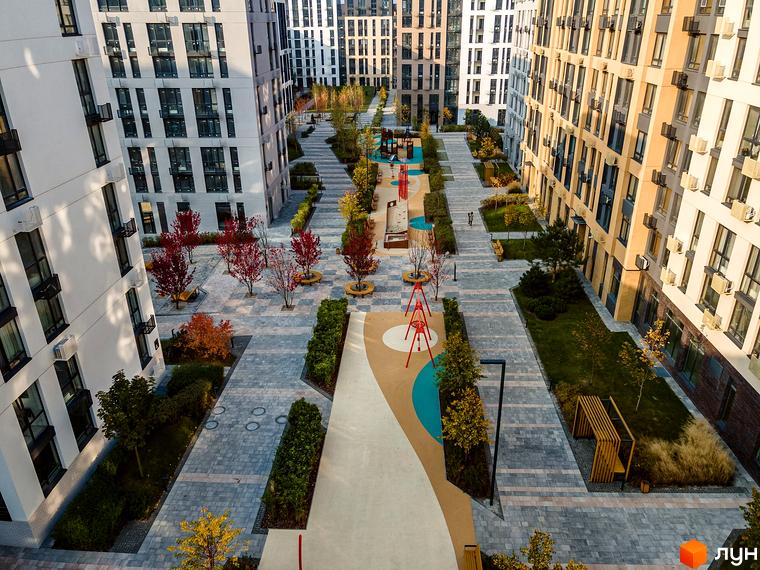 Житловий комплекс Файна Таун: світлі та бежеві будинки, внутрішній двір з доріжками, дитячими майданчиками та осінніми деревами.