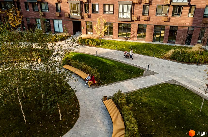 Житловий комплекс Файна Таун з цегляними будинками та доглянутою прибудинковою територією. На території є газони, лавки та доріжки для прогулянок.