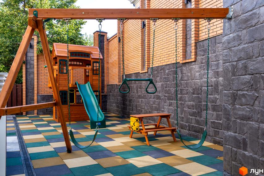 Дитячий майданчик у дворі клубного будинку Hidden. На території є гойдалки, гірка та столик для відпочинку.