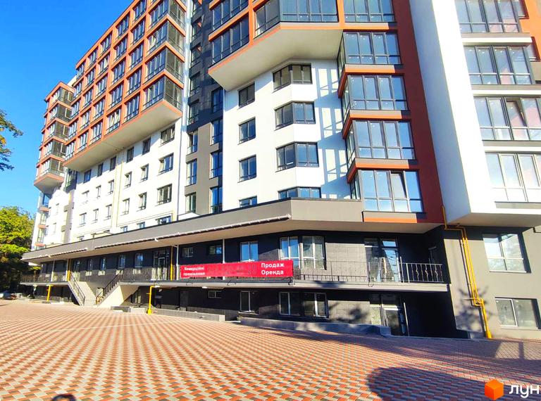 Житловий комплекс Green Life-3. Зовнішній вигляд фасаду будинку з великою кількістю вікон та балконів. Прибудинкова територія з бруківкою.