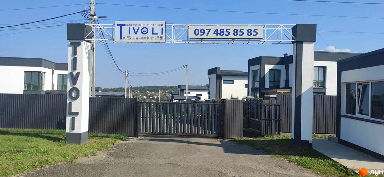 Котеджне містечко Tivoli. В'їзд до комплексу з сірим парканом та сучасними будинками.