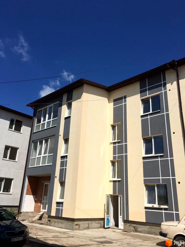 Зовнішній вигляд новобудови ЖК Flat city з сірими та бежевими фасадами, великими вікнами та прибудинковою територією.