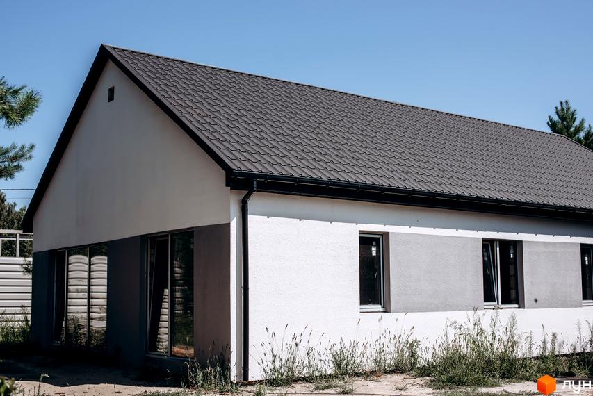 Котеджне містечко КМ Chaletville: двоповерховий будинок з сірим дахом та біло-сірими стінами, вікнами та зеленню навколо.