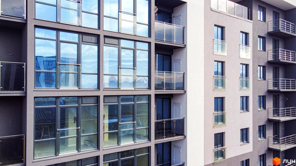 Зовнішній вигляд новобудови Park Residence з великими панорамними вікнами та балконами. Фасад будівлі виконаний у сірих тонах.