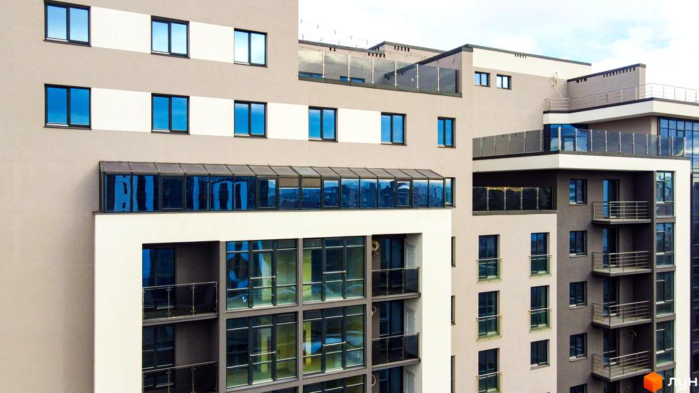 Новобудова Park Residence з панорамними вікнами та балконами. Зовнішній вигляд будівлі з сірими та білими фасадами.