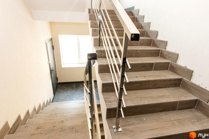 Сходи в ЖК Park Residence з металевим поручнем. Фотографія сходової клітки з дверима та вікном.