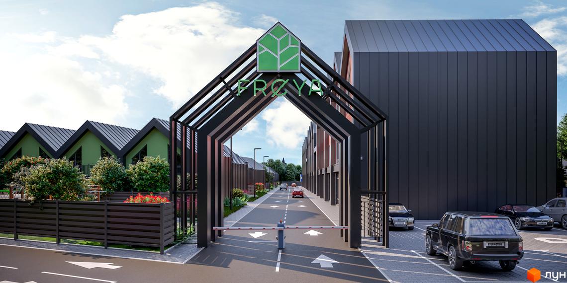 Таунхауси Freya: сучасний архітектурний комплекс із зеленими фасадами та впорядкованою прибудинковою територією. В'їзд до комплексу обладнаний шлагбаумом.