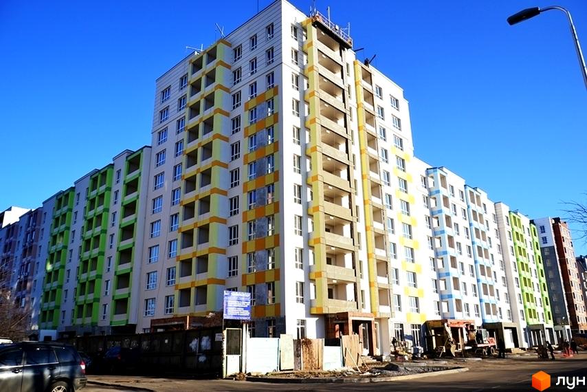 Житловий комплекс Акварелі. Багатоповерхові будинки з різнокольоровими фасадами та встановленими вікнами, що знаходяться на етапі будівництва.