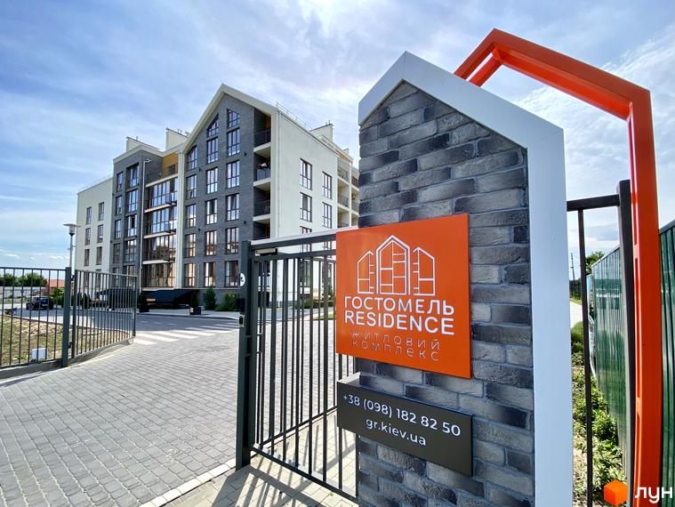 Новобудова Гостомель Residence: багатоповерховий будинок з фасадами світлих та темних кольорів, великими вікнами та огородженою територією.