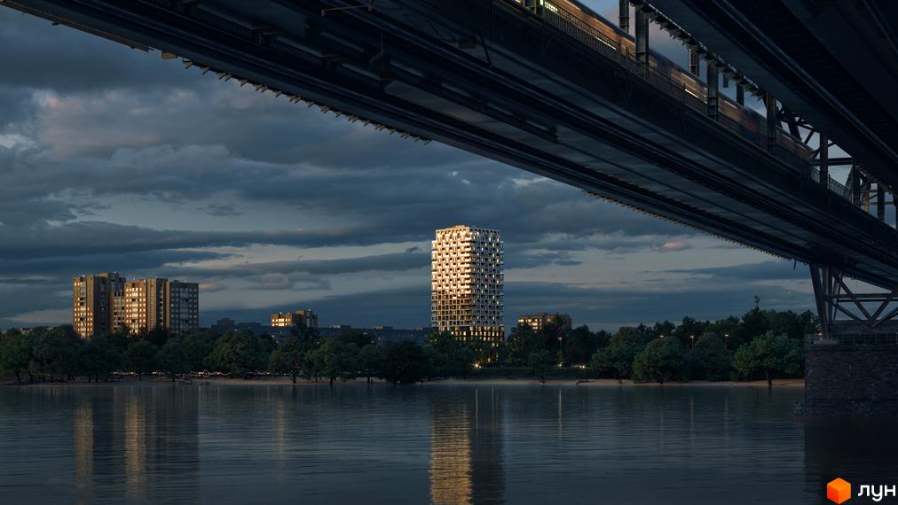 Висотна будівля житлового комплексу Kub29 з великою кількістю вікон, розташована біля річки. Навколо будинку зелені дерева та спокійна вода.