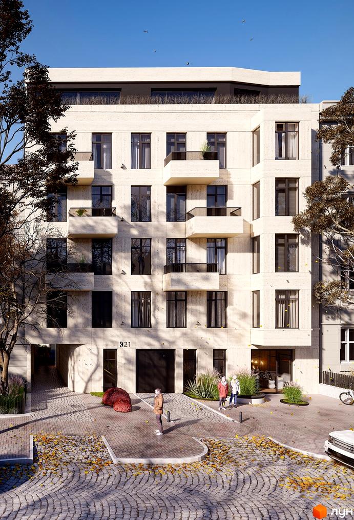 Житловий комплекс на вул. Коновальця, 21 має світлий текстурований фасад з балконами. Прибудинкова територія вимощена бруківкою, вкрита осіннім листям.