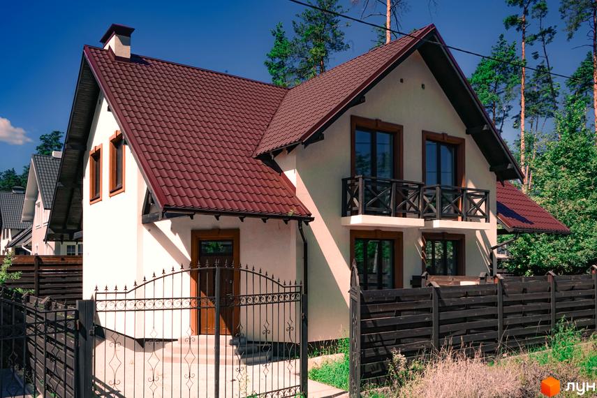 Будинок з коричневим дахом та дерев'яними вікнами, огороджений парканом. Зовнішній вигляд новобудови на пров. Революції, 1б.