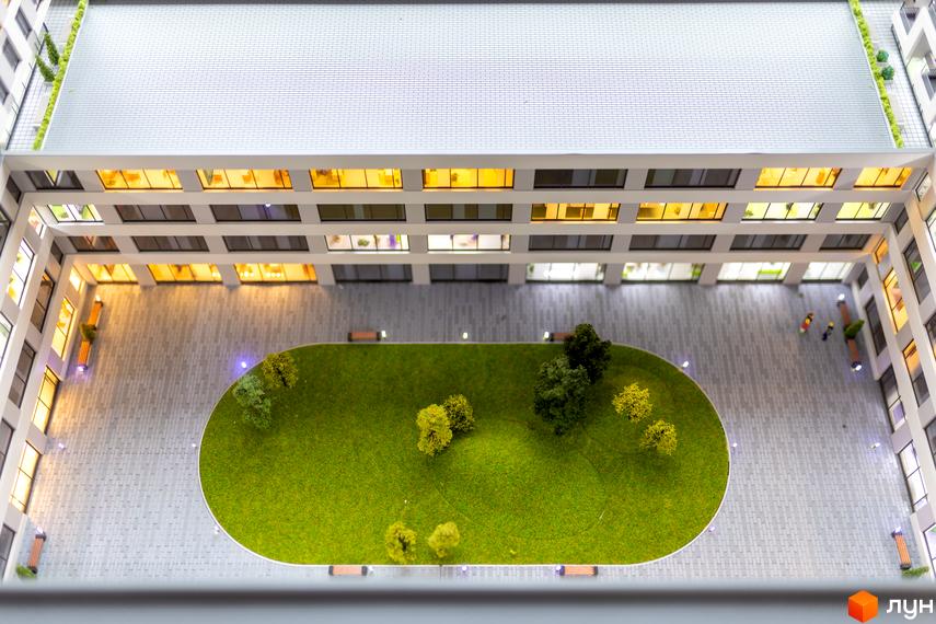 Вигляд зверху на Житловий комплекс BOSTON Creative House з внутрішнім двором, де розташовані дерева та лавки для відпочинку.