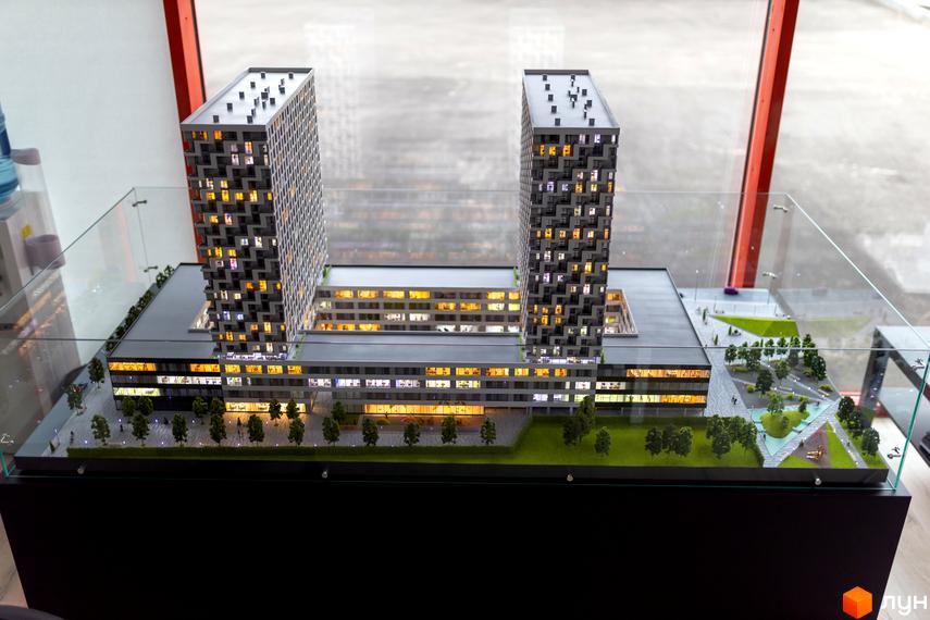 Модель житлового комплексу BOSTON Creative House: дві висотні будівлі з освітленими вікнами та озеленена прибудинкова територія з деревами та доріжками.