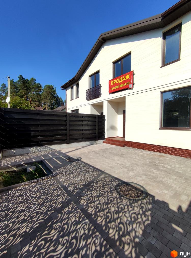 Таунхауси Travertino: білий двоповерховий будинок з червоною цегляною основою та темним парканом. Прибудинкова територія вимощена плиткою з візерунком тіні.