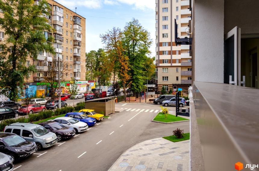 Зовнішній вигляд будинку ЖК Святобор з парковкою та дитячим майданчиком. Фото новобудови та прибудинкової території.