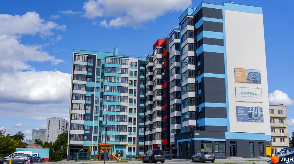 Новобудова ЖК Bridge Town з блакитними та сірими фасадами, вікнами та балконами. Поруч дитячий майданчик та прибудинкова територія.