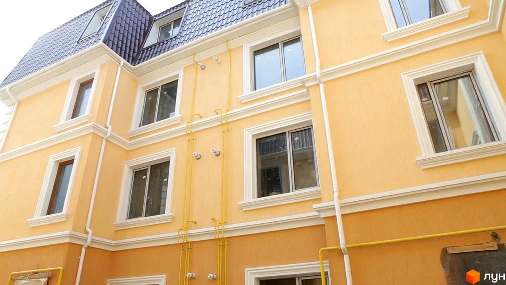 Зовнішній вигляд будинку житлового комплексу Леваневський. Фасад будівлі виконаний у світлих тонах з білими декоративними елементами.