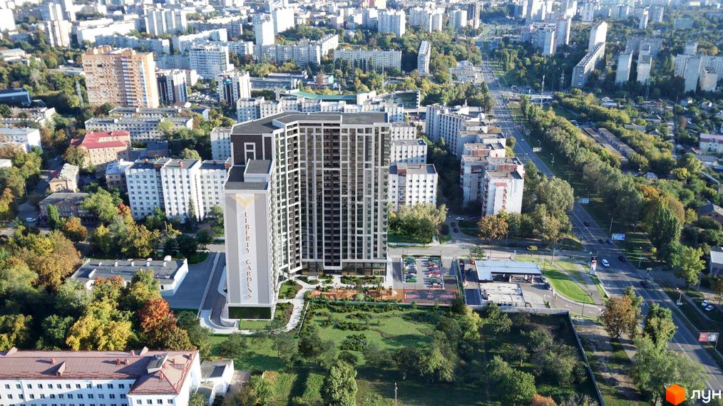 Вид на новобудову Liberty Gardens з фасадом з вікон та прибудинковою територією з зеленню та дитячим майданчиком. Комплекс розташований серед міської забудови.