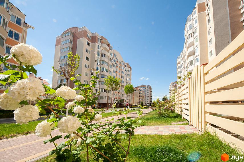 Житловий комплекс Петрівський квартал з сучасними будинками та зеленими насадженнями на прибудинковій території.