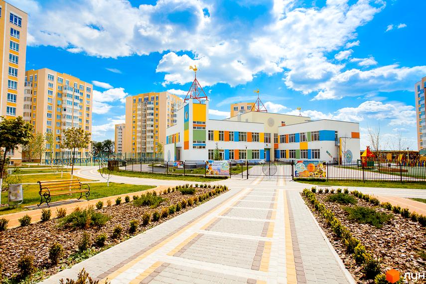 Житловий комплекс Петрівський квартал. Фасад дитячого садка з яскравими кольоровими елементами та прилегла територія з ландшафтним дизайном.