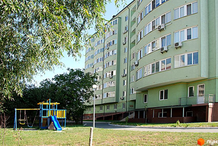 Житловий комплекс Green House з округлими балконами та прибудинковою територією з дитячим майданчиком.