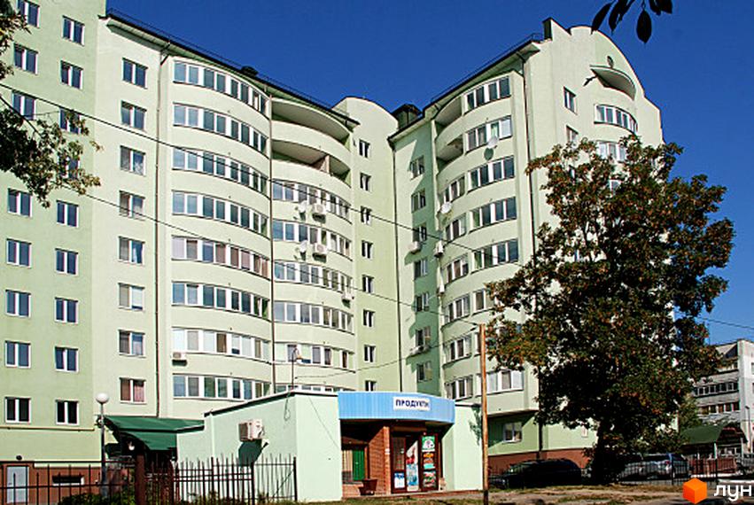 Житловий комплекс Green House з гладкою фасадною поверхнею та великими вікнами. Прибудинкова територія озеленена деревами та має зону для відпочинку.