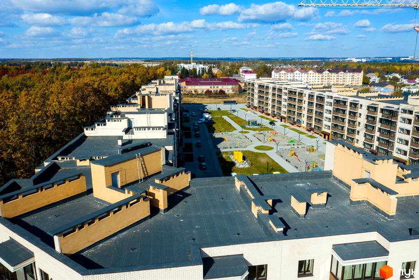 Житловий комплекс Софія: вигляд згори на багатоповерхові будинки з жовтими фасадами та пласкими дахами. На прибудинковій території облаштований дитячий майданчик та зелені зони.