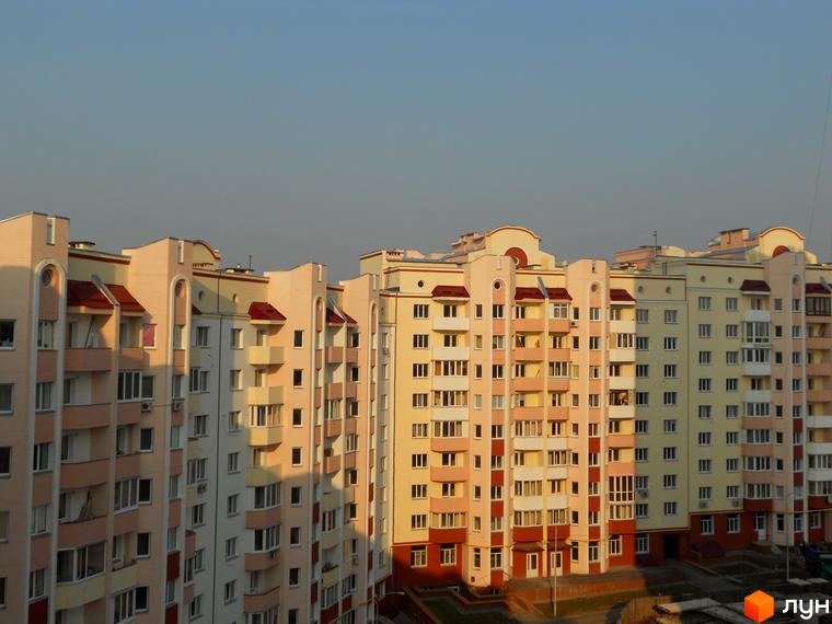 Житловий комплекс Чисті сосни з сучасними фасадами та прибудинковою територією, облаштованою для відпочинку.